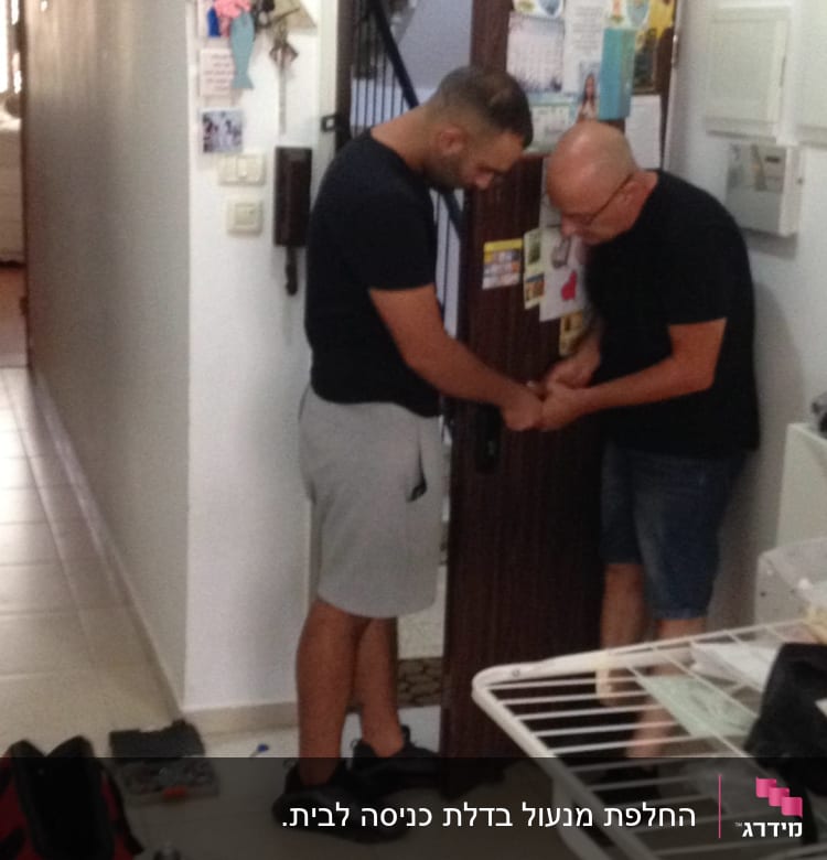 שני אנשים עובדים על מנעול דלת עם כלים שונים